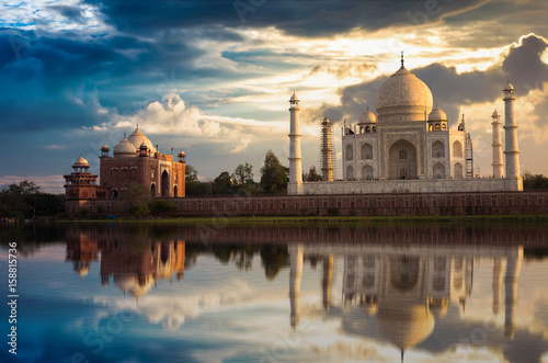 Taj Mahal with a moody sunset sky on the banks of river Yamuna. Taj Mahal is a white marble mausoleum designated as a UNESCO World heritage site at Agra, India.