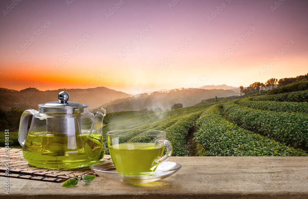 Hot tea in glass tea pot over green background Stock Photo by tenkende