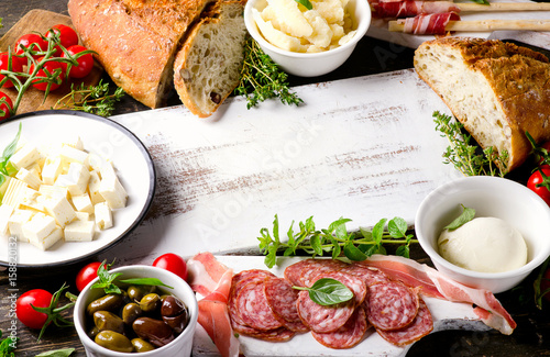 Various types of italian food on wooden table.