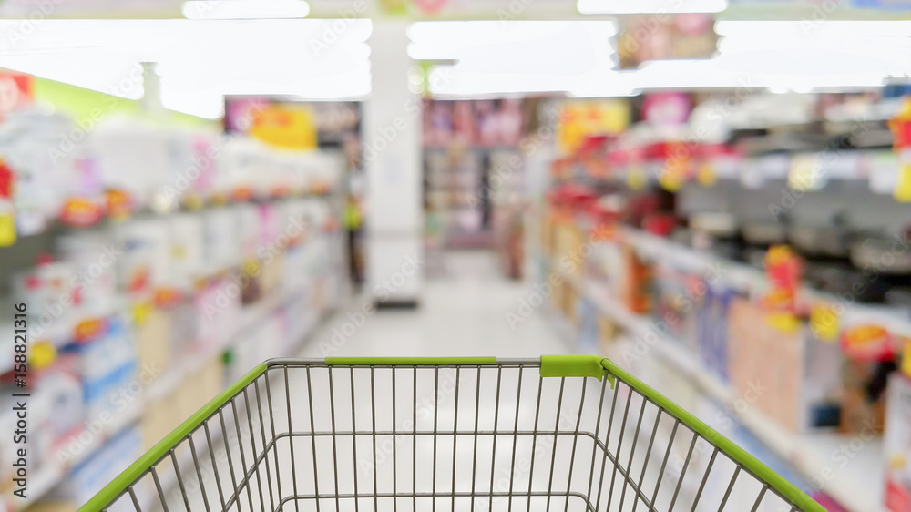 cart in blurred supermarket or department store, shopping concept