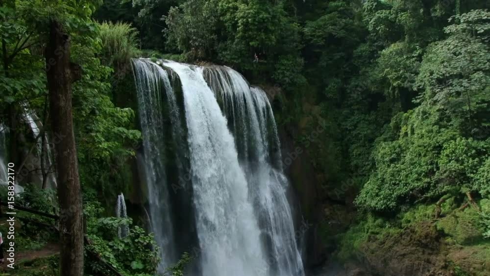 Tilt down of beautiful Pulhapanzak waterfall in Honduras. Man zip lines over waterfall Tilt down of beautiful Pulhapanzak waterfall in Honduras. Man zip lines over waterfall