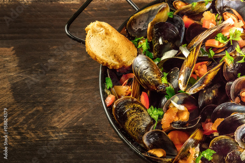 Skillet of marinara mussels on rustic background with copyspace © laplateresca