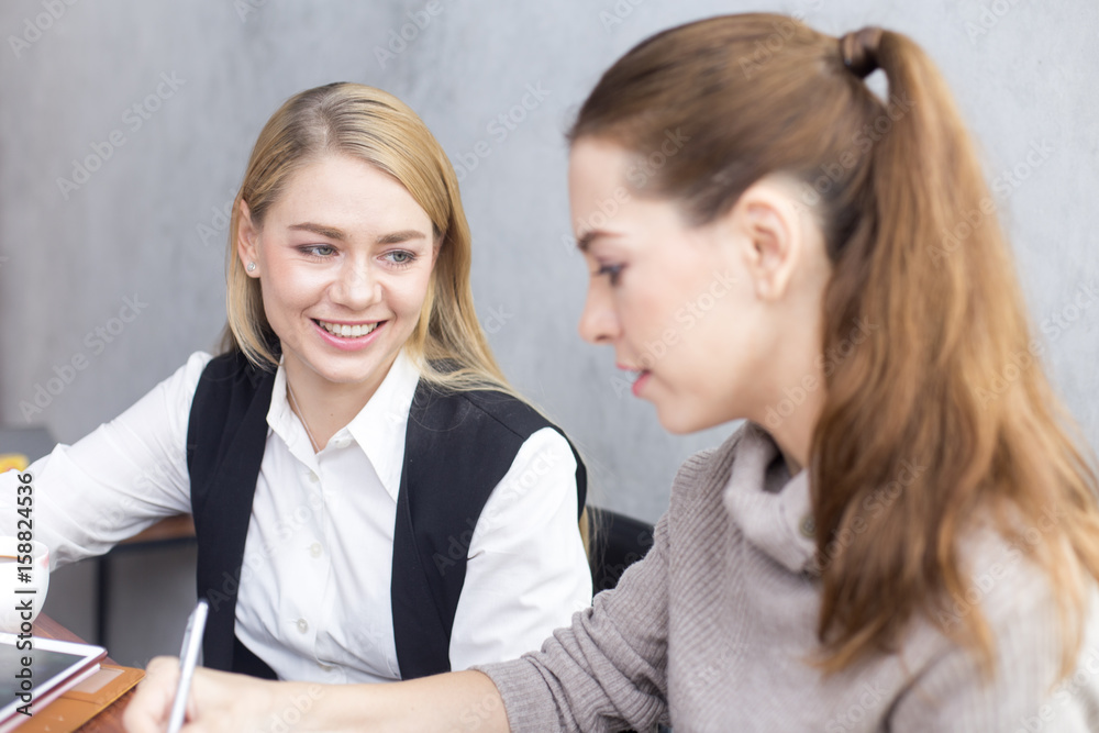 Young woman working together in modern place. Business people takling in modern office. Greeting deal concept Young woman working together in modern place. Business people takling in modern office. Greeting deal concept