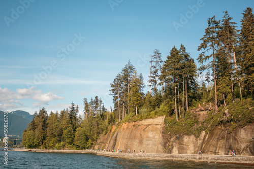 People walking next to rocky wall on Stanley Park, Vancouver, BC