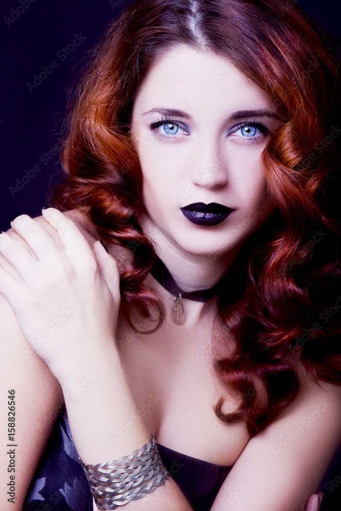 Fototapeta premium Pretty female fashion model posing in studio with dark gothic make up