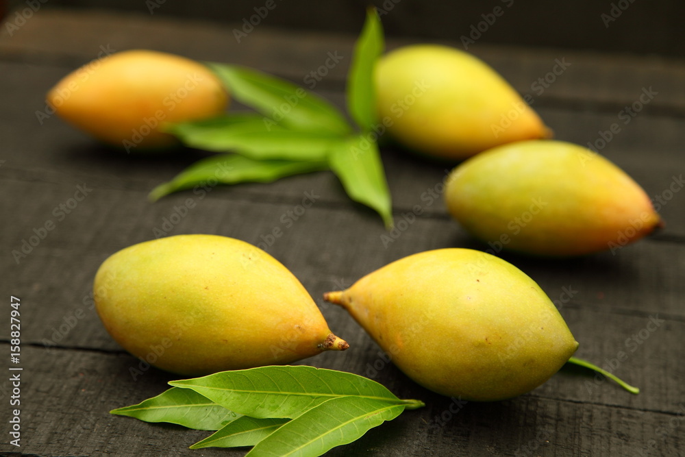 Yellow sweet mangoes on a wooden table.