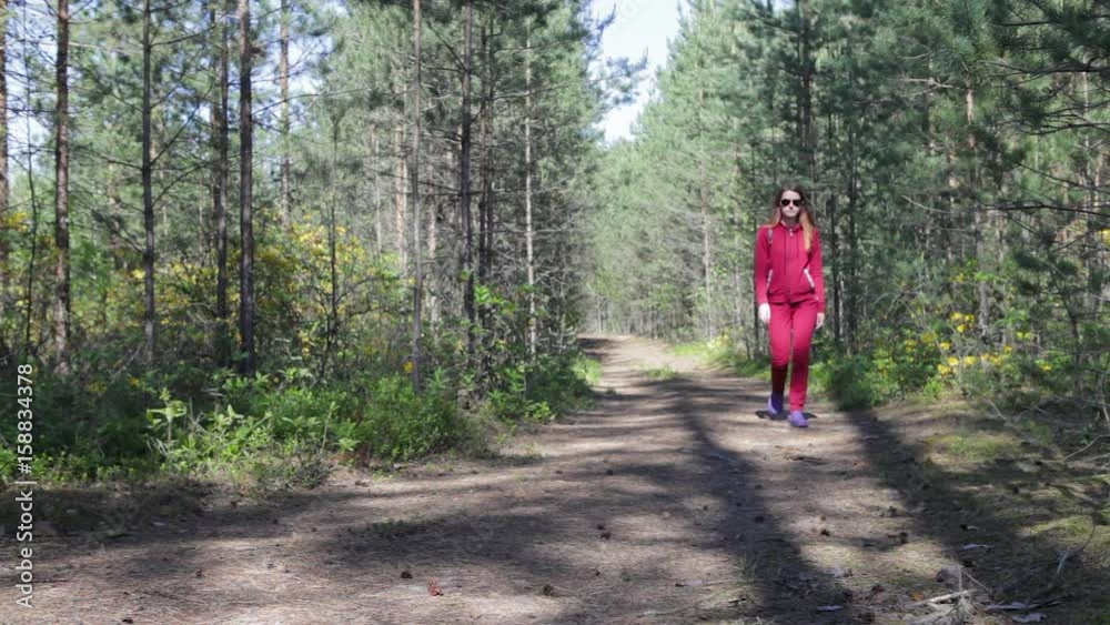 A girl is walking in a park, a forest A girl is walking in a park, a forest