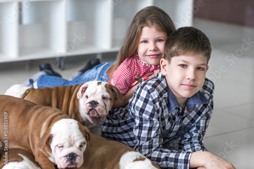 Portrait of little children with cute puppies on the floor