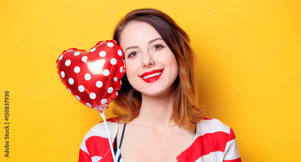 Woman with heart shape toy on yellow background Woman with heart shape toy on yellow background