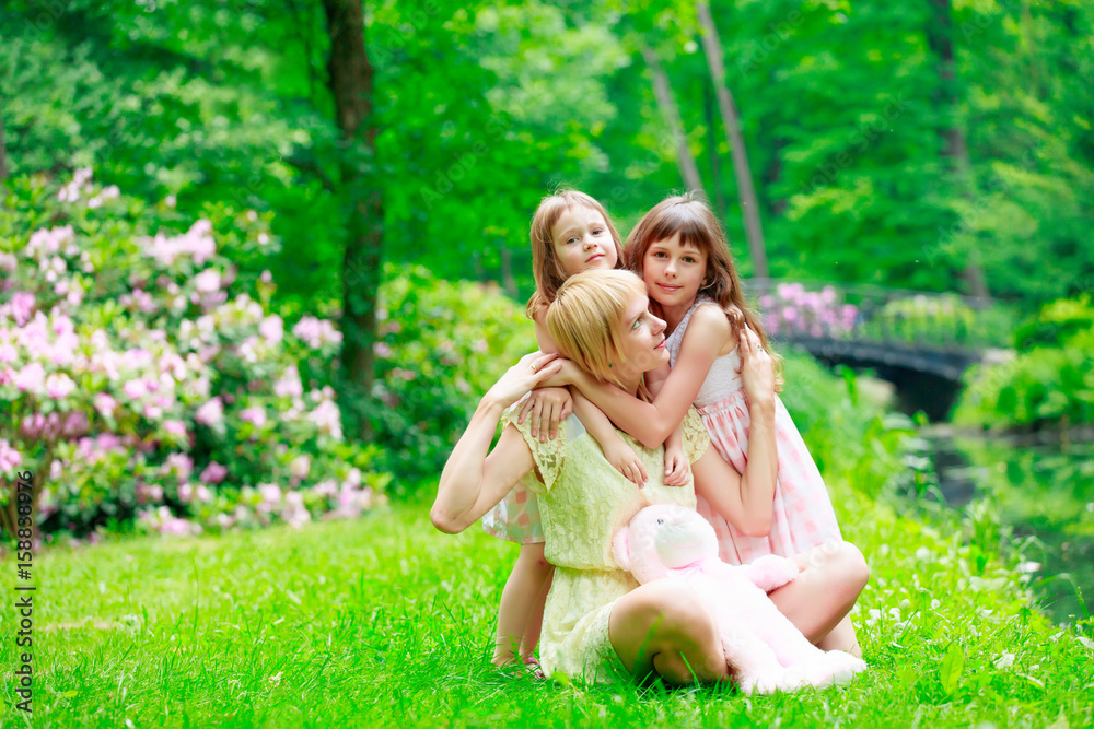 Fototapeta premium Young mother and two sisters in park