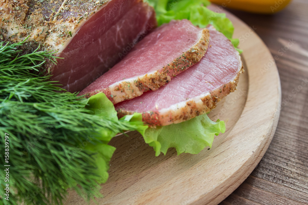 Slices of bacon, lettuce and fresh dill on a wooden plate. Selective focus. Slices of bacon, lettuce and fresh dill on a wooden plate. Selective focus.