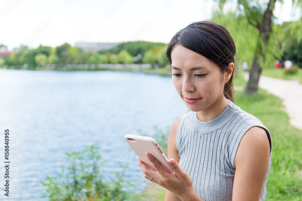 Fototapeta premium Woman use of cellphone in park