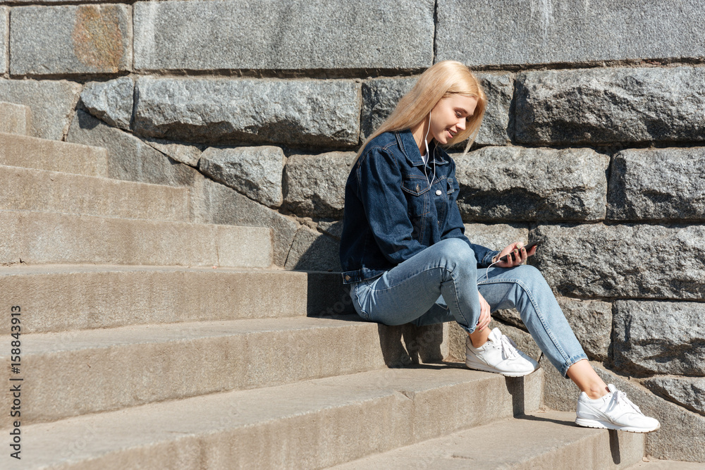 Blonde woman using smarthone and headphones Blonde woman using smarthone and headphones