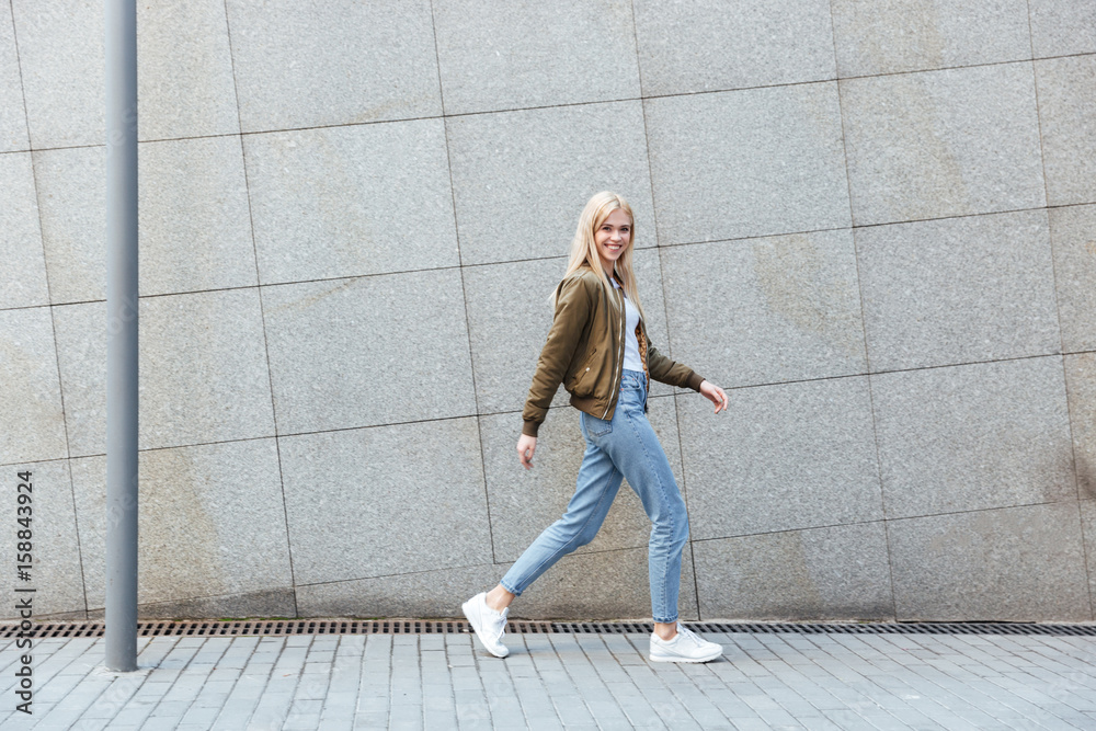Full-length shot of young woman walking in the street Full-length shot of young woman walking in the street
