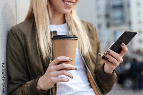 Cropped image of blonde woman using smartphone