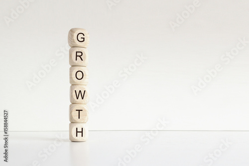 Some wooden letter blocks piled forming the word GROWTH. Improvement business concept. Empty copy space for Editor's text.