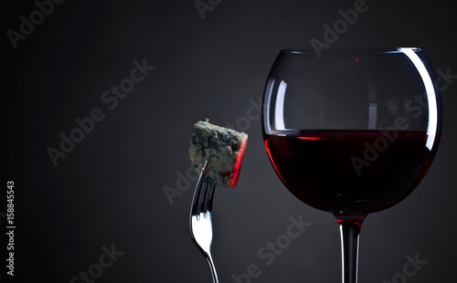 Blue cheese and glass of red wine .