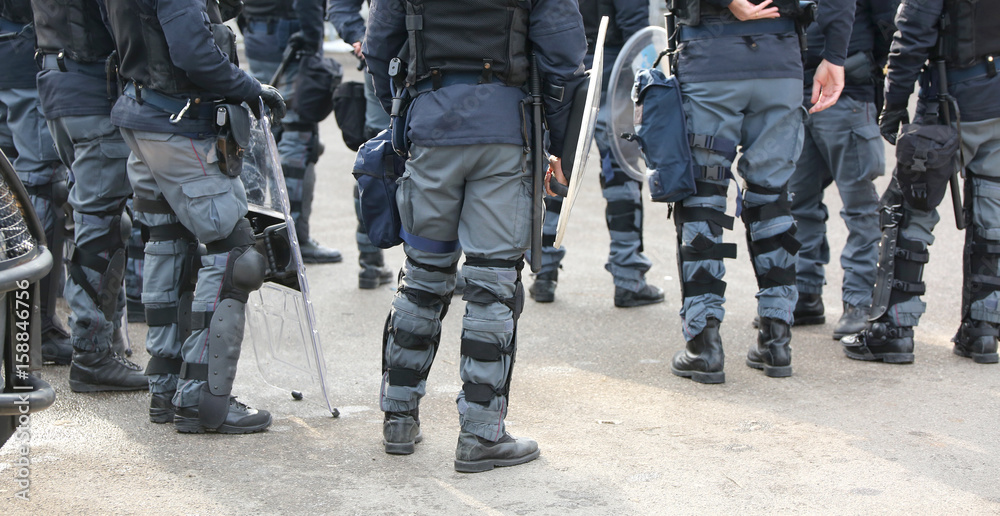 group of police officers in riot control with batons during secu group of police officers in riot control with batons during secu