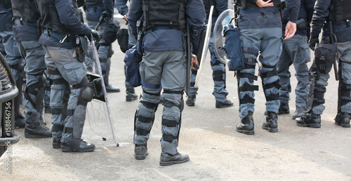 group of police officers in riot control with batons during secu photo