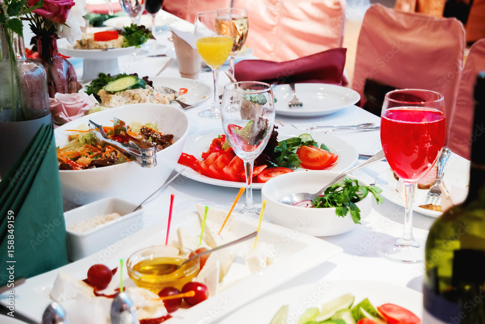 Fototapeta premium Table set for banquet with cutlery. Salads, appetizers and glasses with wine.