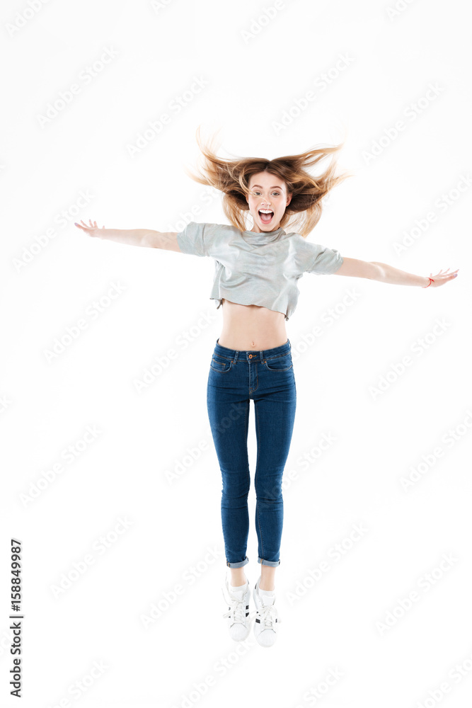 Portrait of a happy pretty girl jumping with hands raised Portrait of a happy pretty girl jumping with hands raised