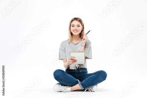 Young woman using pencil and notebook