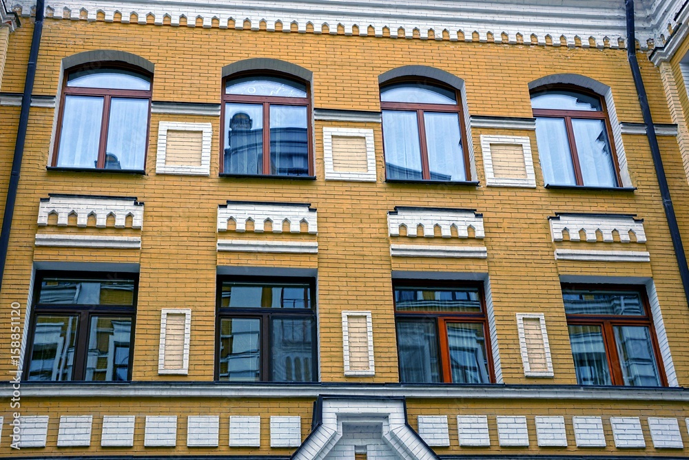 Окна на фасаде коричневого современного многоэтажного здания 