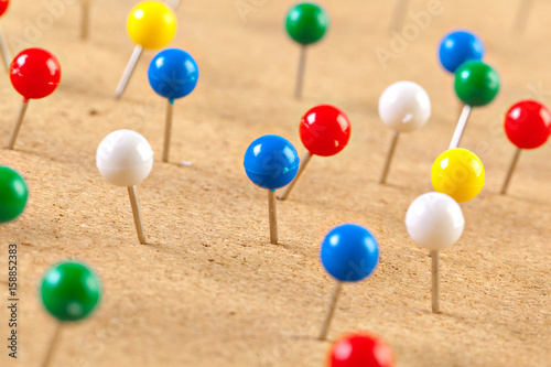 Group of thumbtacks pinned on corkboard