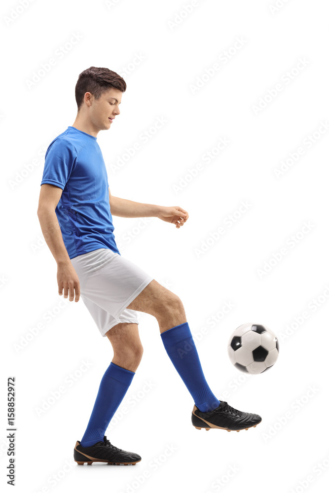Teenage soccer player juggling a football