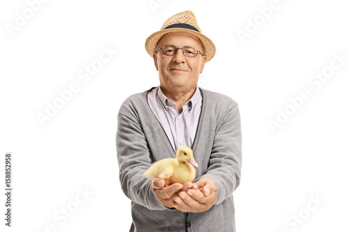 Elderly man with a small duckling