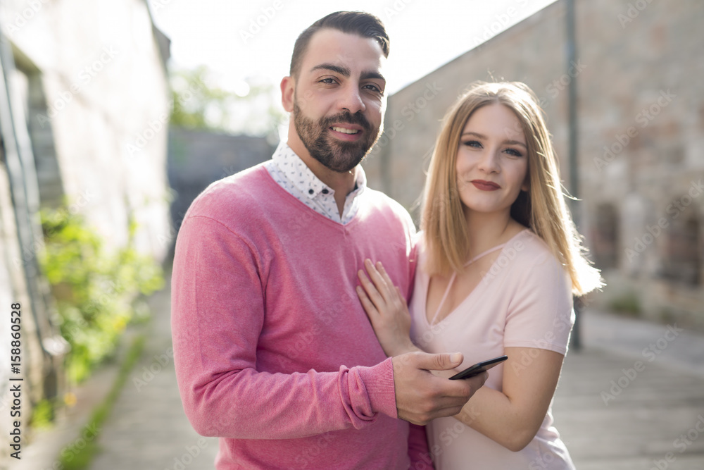 Fototapeta premium Attractive young couple in casual style on a date with cellphone