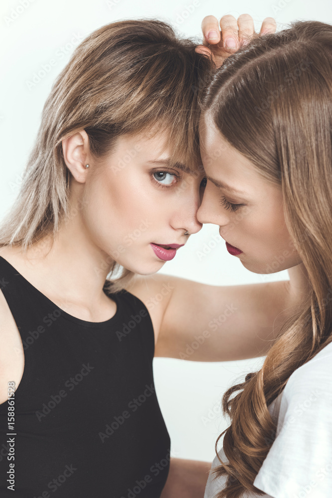 Close-up portrait of beautiful young lesbian couple posing together isolated on white Close-up portrait of beautiful young lesbian couple posing together isolated on white