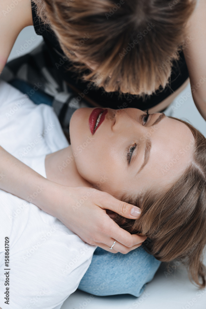 Close-up portrait of sensual young lesbian couple hugging and looking at each other Close-up portrait of sensual young lesbian couple hugging and looking at each other