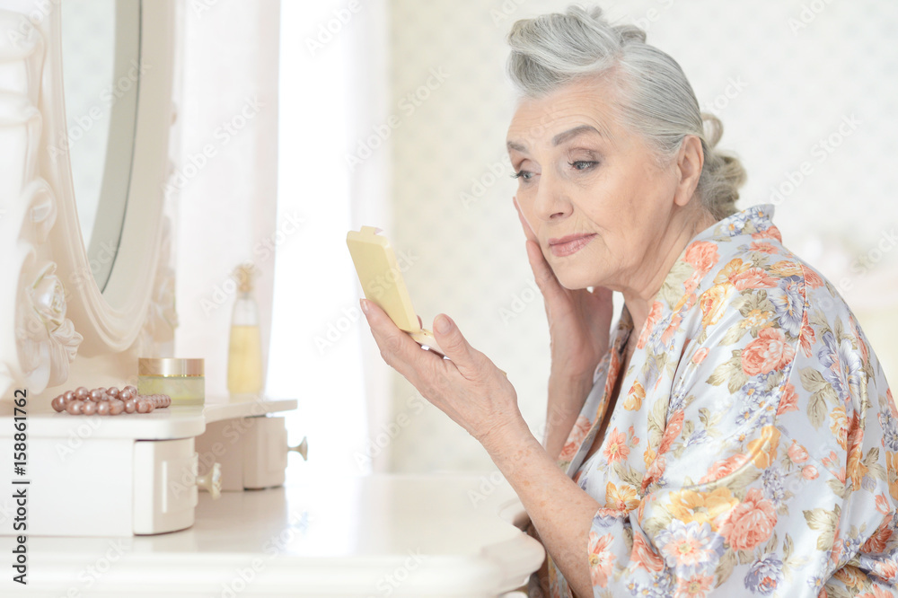 Senior woman applying makeup