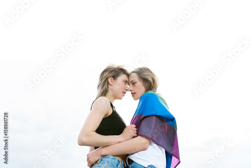 sensual homosexual couple embracing with lgbt flag outdoors © LIGHTFIELD STUDIOS