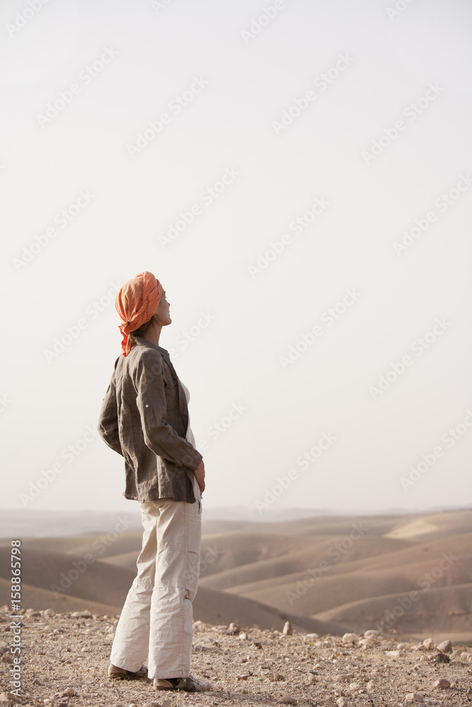 femme avec un foulard qui marche dans le désert Photos | Adobe Stock