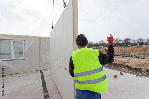 Roofer builder workers with crane installing structural Insulated Panels SIP. Building new frame energy-efficient house photo