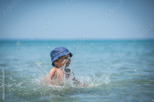 Little boy playing in water on holiday