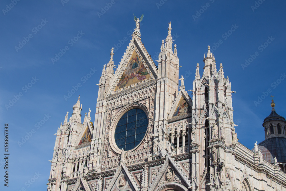 Upper facade detail of Duomo di Siena or Metropolitan Cathedral of Santa Maria Assunta. Tuscany. Italy. Upper facade detail of Duomo di Siena or Metropolitan Cathedral of Santa Maria Assunta. Tuscany. Italy.