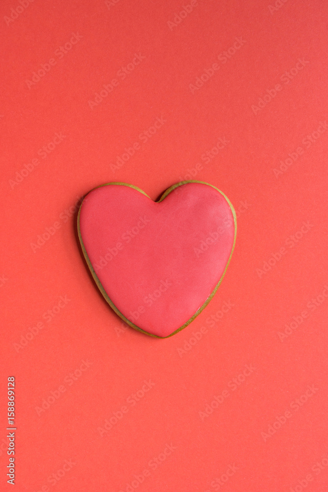 Gingerbread cookie with red icing on the top isolated on red