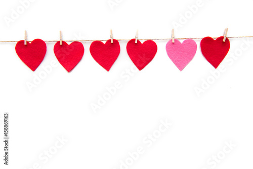 Red heart paper cut decorations hanging on clothespins isolated on white