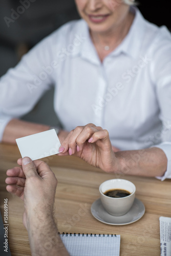 Businessman giving business card to female client