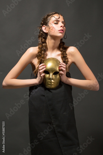 golden mask in hand of mysterious beautiful woman, glamour