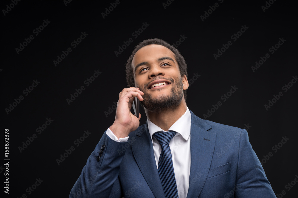 Portrait of successful businessman talking on smartphone isolated on black Portrait of successful businessman talking on smartphone isolated on black