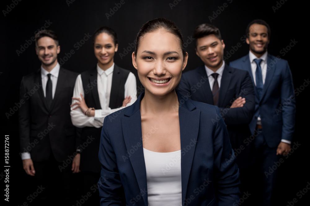 Group of professional business team standing with arms crossed isolated on black Group of professional business team standing with arms crossed isolated on black