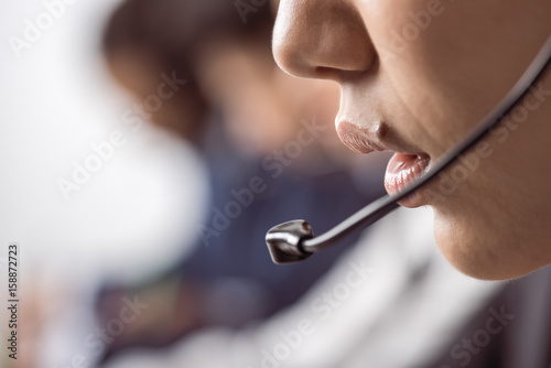Cropped shot of call center operator in headset working and talking with client