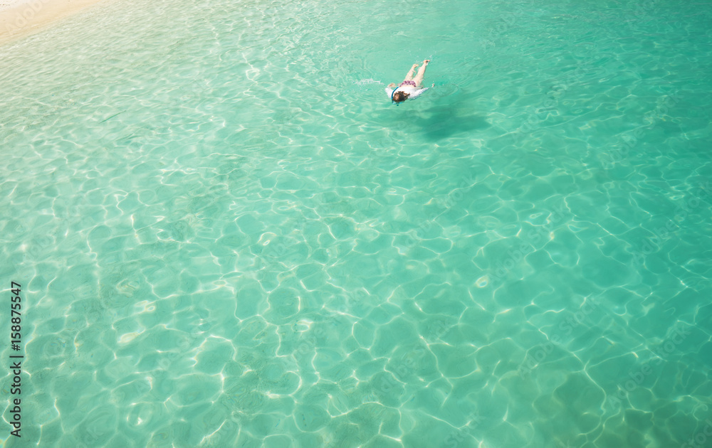 Woman snorkling and relaxing crystal clear and turquoise sea water of the tropical sea .