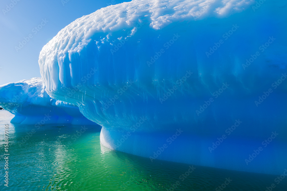 Azure shimmering beautiful iceberg in Antarctica with green reflection ...