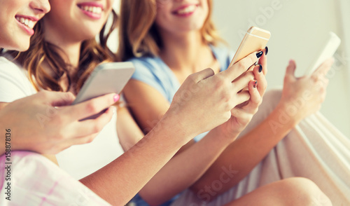friends or teen girls with smartphones at home