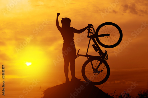 Silhouettes of biker-girl at the sunset